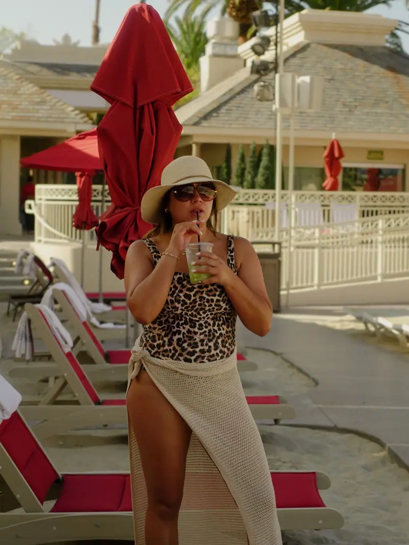 Leopard-print swimsuit with a crochet wrap and sun hat by the pool